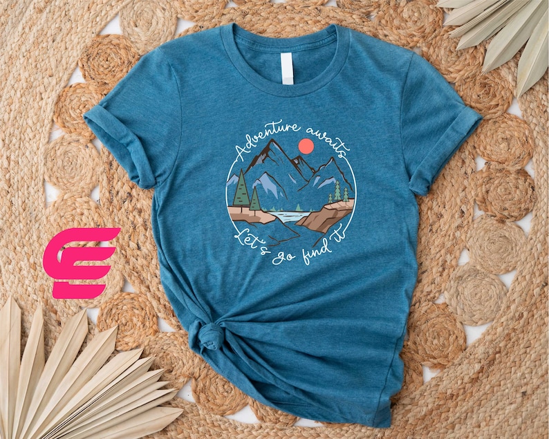 a blue t - shirt with a picture of a mountain on it