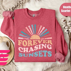 a red shirt with the words forever chasing sunsets on it