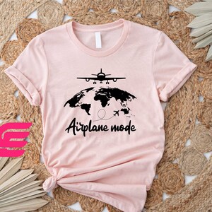 a pink t - shirt with an airplane map on it