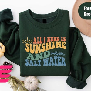 a green shirt with the words all i need is sunshine and salt water on it