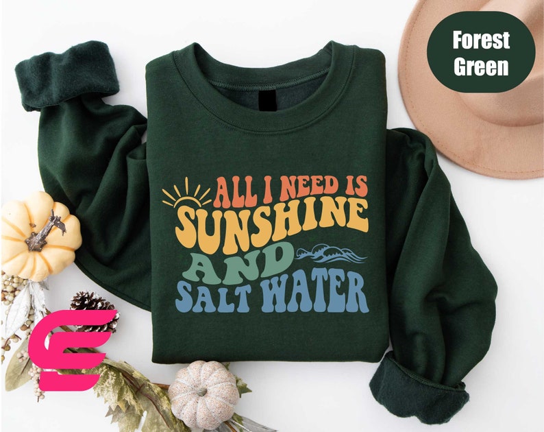 a green shirt with the words all i need is sunshine and salt water on it