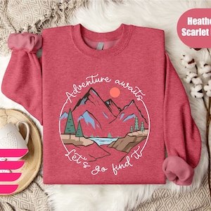 a red sweater with a mountain scene on it