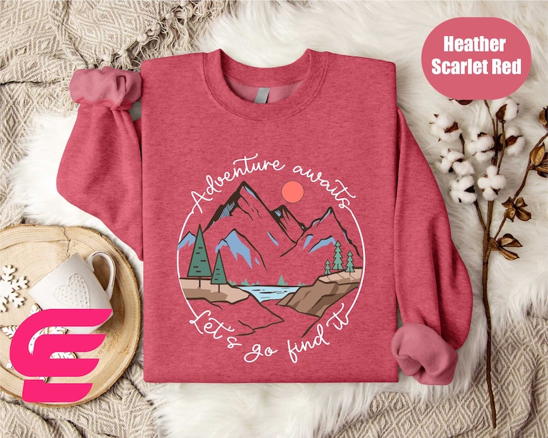 a red sweater with a mountain scene on it