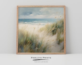May include: A framed print of a beach scene. The artwork depicts a sandy beach with tall green and tan grasses in the foreground. The ocean and sky are visible in the background. The frame is made of light-colored wood. The text "PAWLEYS PRINTS" and "TIMELESS ARTWORK" are at the bottom.