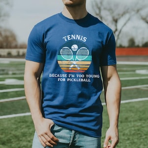 a man standing in a field with a tennis racket