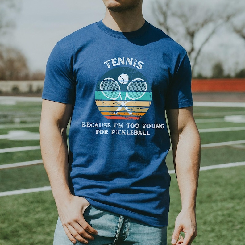 a man standing in a field with a tennis racket
