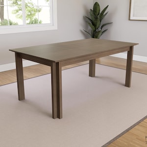 Puede incluir: Una mesa de comedor rectangular de madera con un acabado marrón. La mesa tiene cuatro patas y un diseño sencillo.