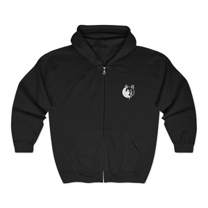 Peut inclure: Sweat à capuche noir zippé avec capuche et poches avant. Un petit motif blanc d'une tête de loup est sur le haut de la poitrine gauche. Le sweat à capuche a une fermeture éclair sur toute la longueur et une capuche à cordon.