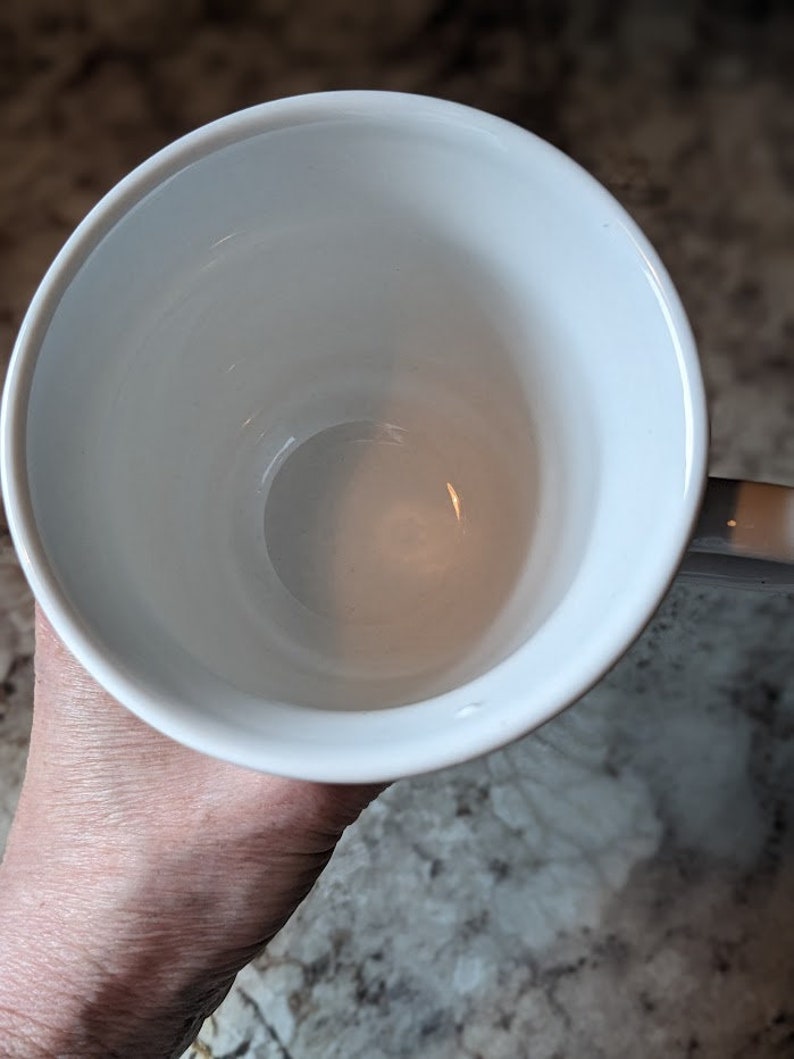 May include: A white ceramic mug with a smooth, glossy finish. The mug is empty and appears to be new.