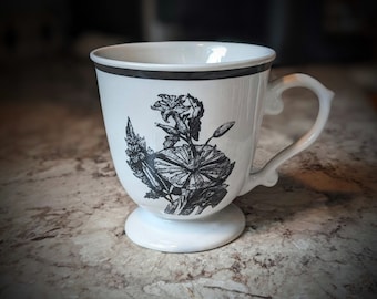 Filiżanka do kawy lub herbaty Anthropologie Pedestal White z czarno-białym wzorem kwiatowym i czarną obwódką