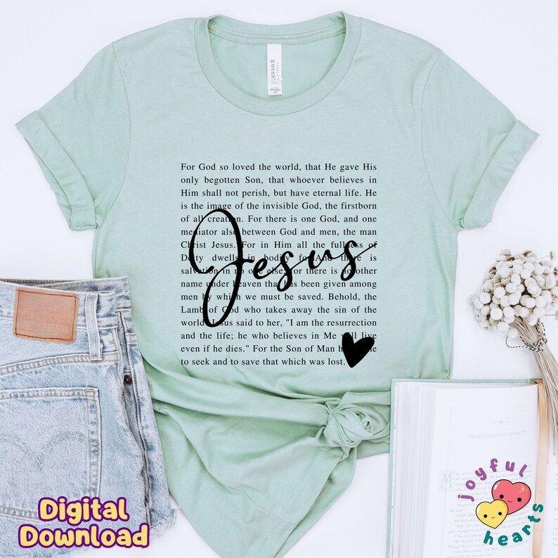 May include: A light green t-shirt with a black print of a Bible verse about Jesus. The text includes the words "For God so loved the world" and "Jesus".