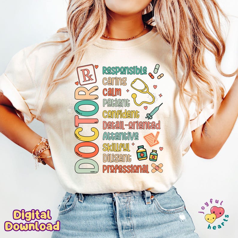 May include: A white t-shirt featuring a colourful graphic design that reads "DOCTOR" and lists attributes of a doctor, including responsible, caring, calm, patient, confident, detail-oriented, attentive, skillful, diligent, and professional. The graphic also incorporates medical symbols such as a stethoscope, a syringe, and a bandage.