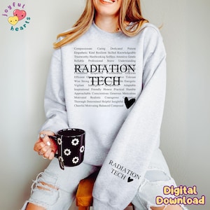 May include: A light gray sweatshirt with the words "RADIATION TECH" and a black heart. The sweatshirt also features a list of positive attributes. A black mug with white daisy patterns is held in the hand.