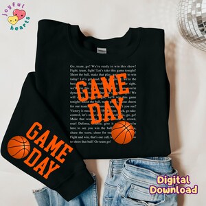 May include: Black sweatshirt with orange text that reads "GAME DAY" and a basketball graphic. The text says "Go, team, go! We're ready to win this show! Fight, team, fight! Let's take this game tonight! Shoot the ball, make that play, we're the best today! Let's get loud, we'll win this game tonight! Shoot the ball, make that play, we'll win this game tonight!"