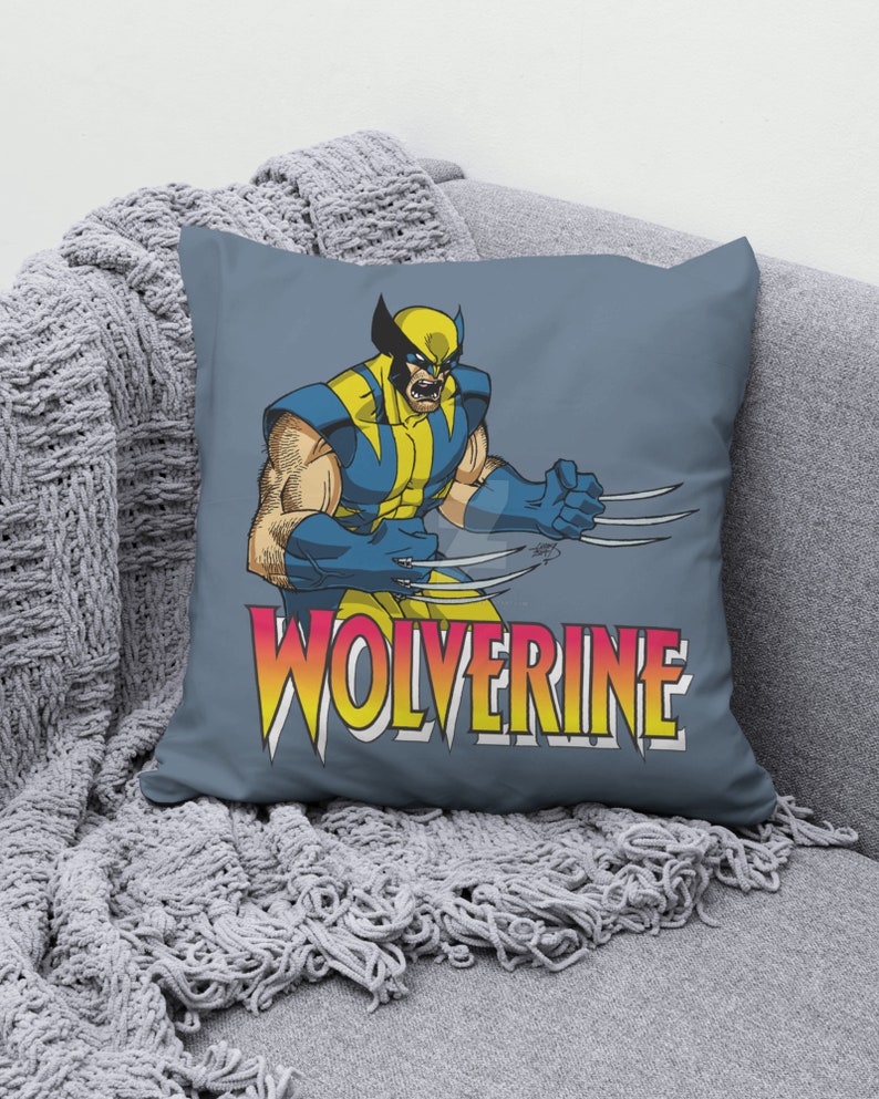 May include: A blue throw pillow with a graphic of Wolverine, a comic book superhero, with the word "Wolverine" in yellow, red, and orange letters.