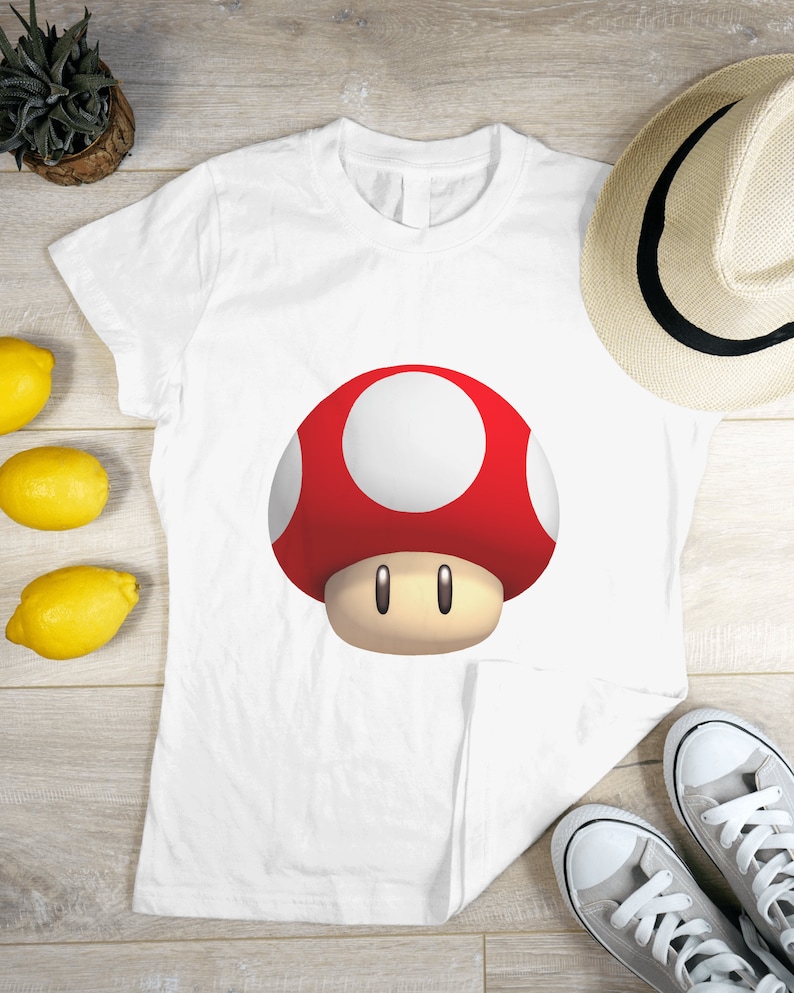 Peut inclure: T-shirt blanc avec un motif de champignon rouge et blanc.