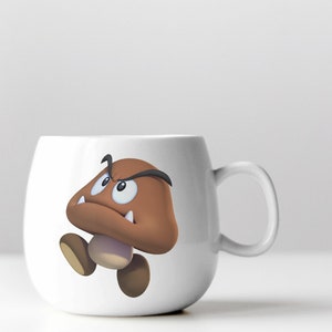 Peut inclure: Une tasse en c&eacute;ramique blanche avec un personnage de champignon de dessin anim&eacute; brun avec un visage renfrogn&eacute; et des dents pointues. Le personnage du champignon porte un sourcil noir.