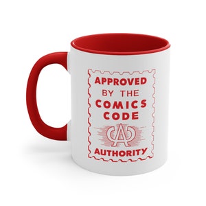 May include: White ceramic mug with a red interior and handle. The mug features a red graphic of a stamp with the text "APPROVED BY THE COMICS CODE AUTHORITY" and a stylized "A" inside a circle.