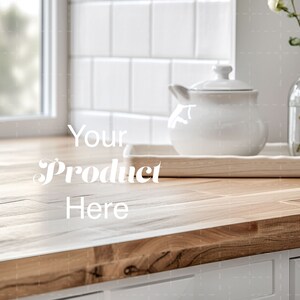 Könnte beinhalten: Eine helle Holztheke mit einer weißen Keramik-Teekanne und einer Glasvase mit weißen Blumen auf einem Holztablett. Der Text "Your Product Here" ist auf der Theke geschrieben.