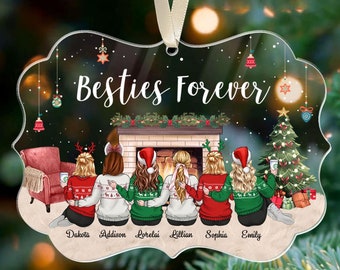May include: A clear acrylic ornament with the text "Besties Forever" and illustrations of six friends sitting by a fireplace and Christmas tree. The ornament has a beige ribbon for hanging. Names of the friends are listed below the illustration.
