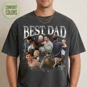 May include: Dark gray t-shirt with the text "BEST DAD" in a silver, retro-style font. The shirt features a collage of photos of fathers with their children. The words "COMFORT COLORS" are in a green circle.