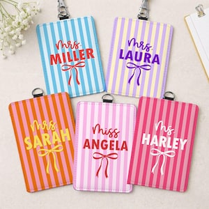 May include: Five rectangular vertical ID badge holders with metal clips, each featuring a striped pattern and a printed name with a bow graphic. The holders are colored in light blue, yellow and purple, orange and pink, light pink, and dark pink.