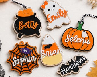 Könnte beinhalten: Sechs Halloween-Anhänger aus Acryl mit personalisierten Namen: Betty auf einem schwarzen Kessel, Emily auf einem weißen Geist, Selena auf einem orangefarbenen Kürbis, Sophia auf einem Spinnennetz, Brian auf einem Zuckermais und Harrison auf einer Fledermaus.