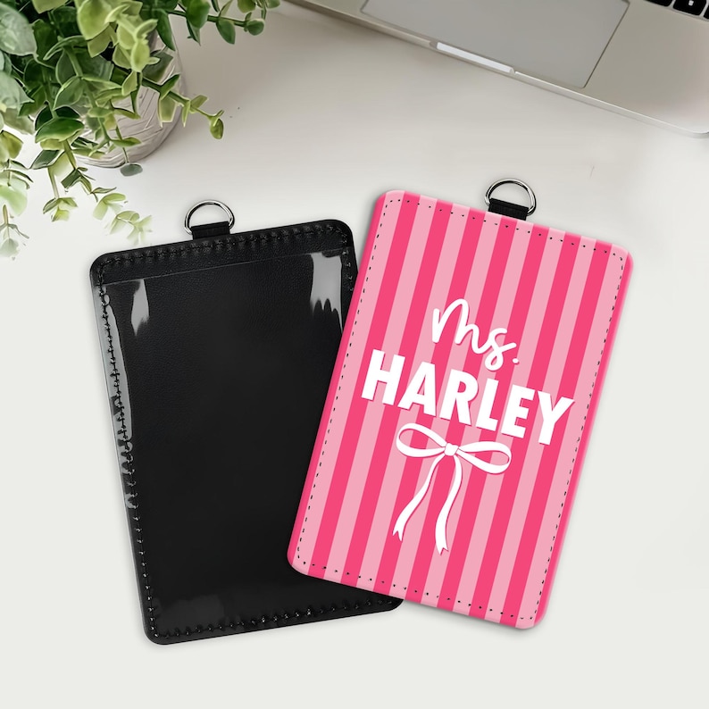 May include: Two rectangular badge holders with metal rings at the top. One holder is solid black with a clear front window. The other holder features a pink and light pink vertical striped pattern with the white text Ms. HARLEY and a white bow.