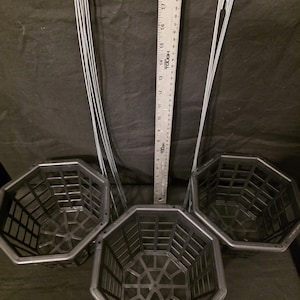 May include: Three black, octagonal hanging baskets with wire hangers. A ruler shows the baskets are approximately 10 inches in diameter. The baskets have a grid-like design and are made of a durable plastic material.