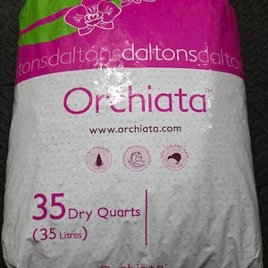 May include: A large plastic bag of Daltons Orchiata orchid potting medium. The bag is white with a pink top section featuring orchid graphics. Text includes Orchiata, www.orchiata.com, and 35 Dry Quarts (35 Litres). Three circular icons are visible.