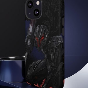 May include: Black phone case with a graphic of a character from the anime Berserk. The character is wearing black armor and has a red helmet. The phone case is on a blue surface.