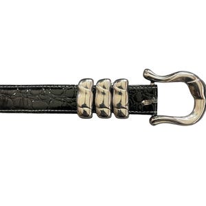 Op de afbeelding: Een zwarte leren riem met een zilveren gesp. De gesp heeft een uniek ontwerp met drie in elkaar grijpende ringen.
