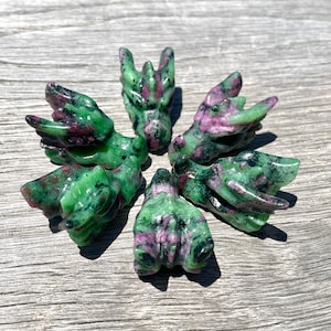 May include: Six green and pink dragon head carvings made from green aventurine gemstone.
