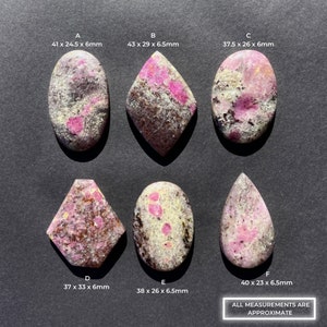 May include: Six cabochon gemstones with pink and white patterns on a dark gray background. The gemstones are oval, diamond, and teardrop shapes. The measurements of each gemstone are listed below each stone. All measurements are approximate.