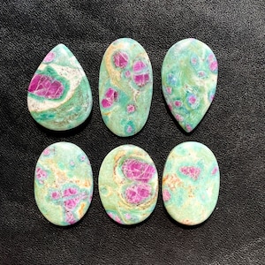以下が含まれることがあります： 緑とピンクの楕円形と涙滴形の宝石のカボションが6つ。石は緑、白、ピンクの渦巻き模様をしています。