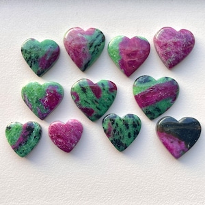 May include: Twelve heart-shaped green and pink gemstones with black flecks.