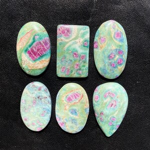 May include: Six green, pink and white cabochon gemstones in a variety of shapes, including oval, rectangle and teardrop.