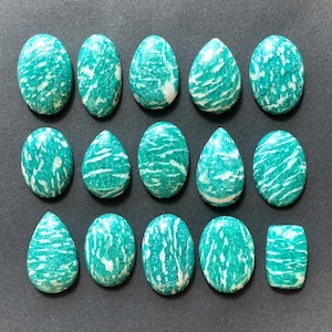 May include: A collection of 15 green and white amazonite cabochons, some oval and some teardrop shaped.