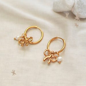 Oorbellen met strik | Goudkleurig | Roestvrijstalen oorbellen | Strikje als hanger | Parelbedeltje | 12, 14, 16, 18, 20 mm