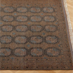 以下が含まれることがあります： 茶色のラグで、茶色と青色の色合いで接続された楕円形のデザインが繰り返されています。 ラグは房状の縁があり、織られた素材で作られています。