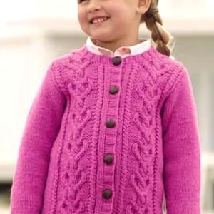 May include: A bright pink, knitted cardigan with a cable knit design. The button-down sweater has dark brown buttons and long sleeves. The child's sweater is a classic style, perfect for layering in cooler weather.
