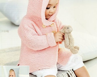 Puede incluir: Una chaqueta de punto rosa para bebé con capucha y cierre de botones. La chaqueta está hecha con punto doble y tiene un diseño sencillo. El bebé está sosteniendo un conejito de peluche.