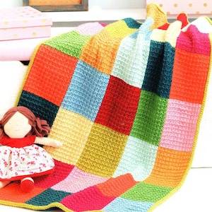 May include: A colorful knitted baby blanket with a patchwork design in shades of red, orange, yellow, green, blue, and pink. The blanket is made with a textured stitch and has a yellow border.