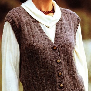 Puede incluir: Un chaleco de punto marrón con cuello en V y cierre de botones. El chaleco es sin mangas y tiene una textura acanalada.