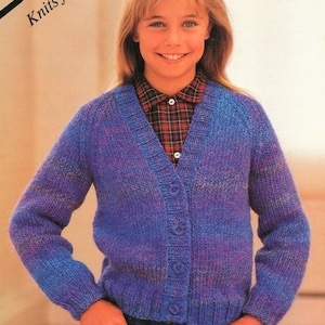 May include: A blue and purple cardigan with a button-up front. The cardigan is knitted from 3 balls of yarn. The text "Fascination Chunky 26-32inch 66-81cm" is visible in the top right corner of the image.