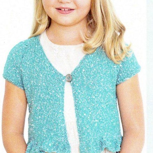 May include: A turquoise knitted short-sleeved cardigan with a speckled pattern and a single button fastening. The cardigan has a ruffled hem and a V-neck design. The garment is made of a soft, textured material.