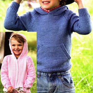 May include: Two children wearing knitted hooded sweaters. The child on the left is wearing a pink sweater and the child on the right is wearing a blue sweater. Both children are wearing jeans.