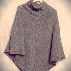 May include: Gray knitted poncho with a turtleneck and a cable knit pattern.