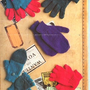 May include: A collection of knitted fingerless gloves and mittens in various colours, including blue, purple, red, and green. The gloves are displayed on a brown surface with various printed papers.