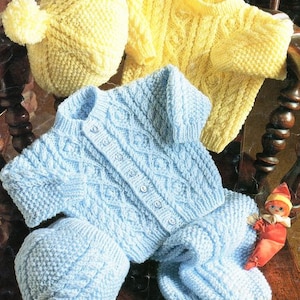 May include: Two knitted baby sweaters, one blue and one yellow, with matching knitted hats. The sweaters have a cable knit pattern and button closures. The hats have pom-poms.